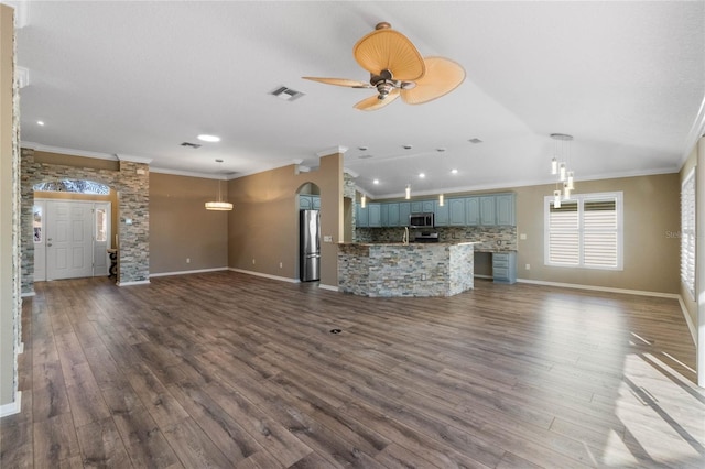 unfurnished living room with ceiling fan, dark hardwood / wood-style flooring, and ornamental molding