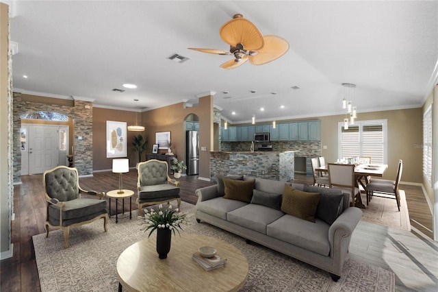 living room featuring crown molding, ceiling fan, and hardwood / wood-style flooring