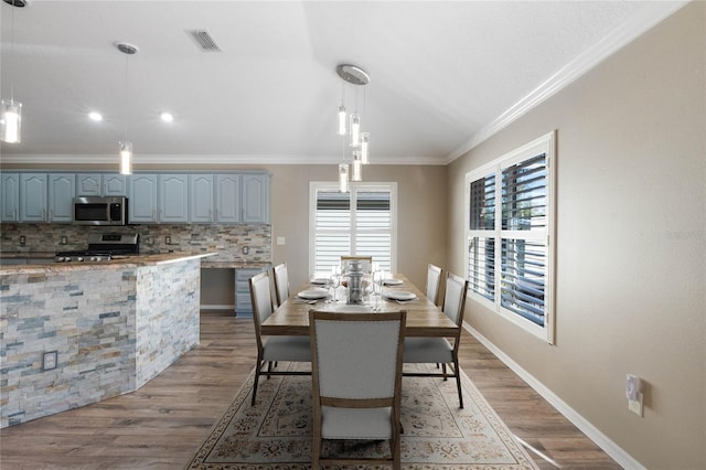 dining room with light hardwood / wood-style floors and ornamental molding