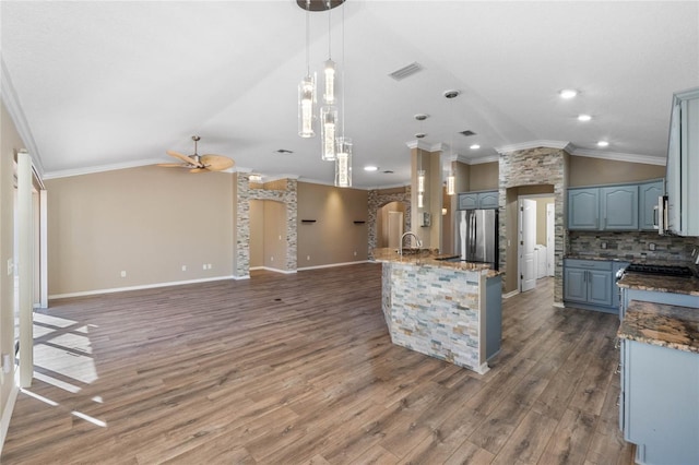 kitchen featuring appliances with stainless steel finishes, dark hardwood / wood-style flooring, ornamental molding, ceiling fan, and hanging light fixtures