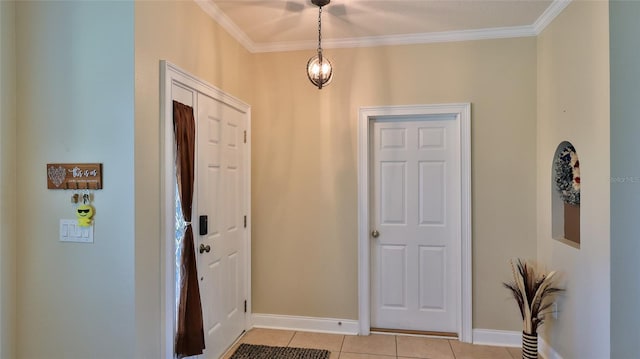 tiled foyer entrance featuring ornamental molding and a chandelier