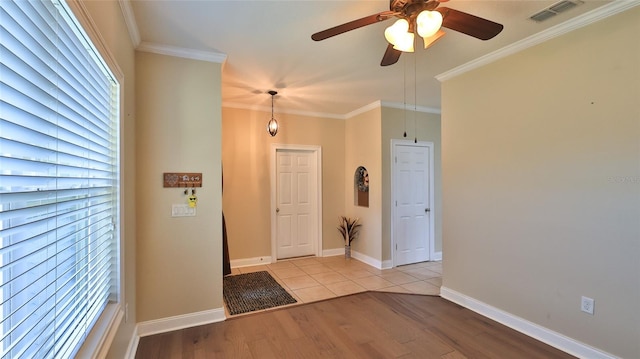 entryway featuring light wood-type flooring, ceiling fan, and crown molding