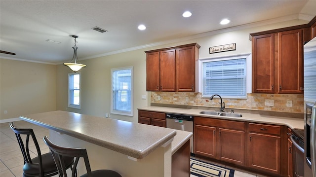 kitchen featuring a kitchen breakfast bar, crown molding, sink, and decorative light fixtures