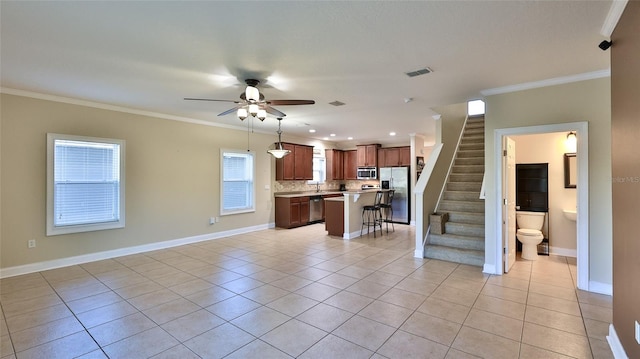 kitchen with a kitchen bar, appliances with stainless steel finishes, backsplash, and light tile patterned floors