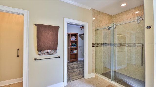 bathroom with ornamental molding, tile patterned floors, and a shower with shower door