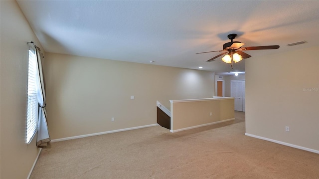 unfurnished room featuring ceiling fan and light colored carpet