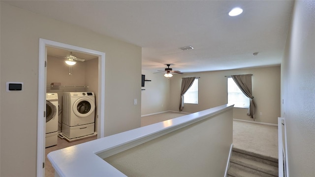 hall with light colored carpet and washer and dryer