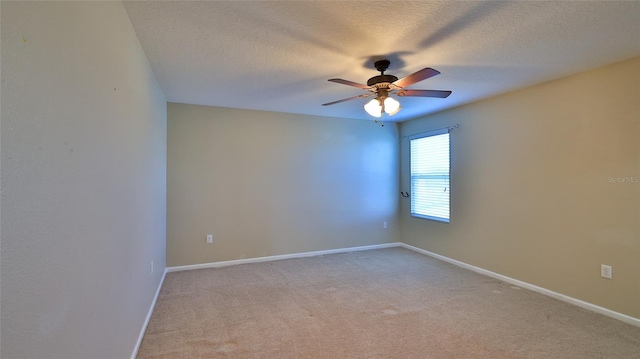 empty room featuring light carpet, ceiling fan, and a textured ceiling