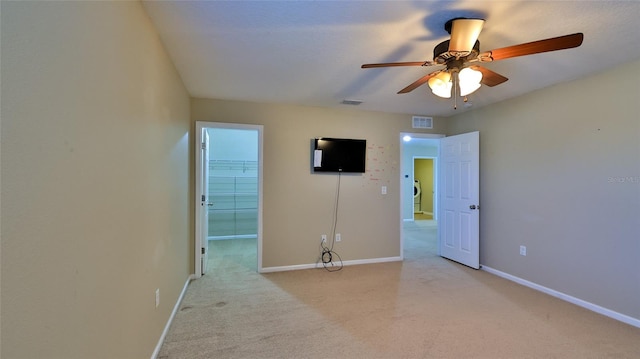 spare room with ceiling fan and light colored carpet