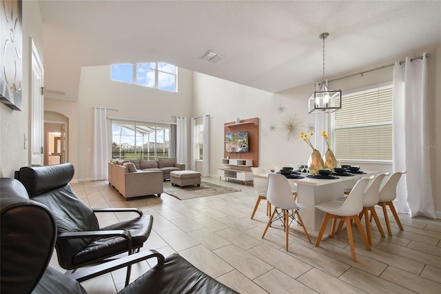 dining room featuring high vaulted ceiling, light tile patterned floors, and a notable chandelier