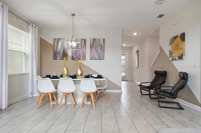 dining space with light tile patterned floors and an inviting chandelier