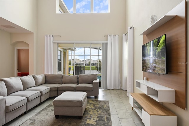 8942 Cabot Cliffs Dr, Davenport, FL 33896 - living area with a high ceiling, arched walkways, and healthy amount of natural light