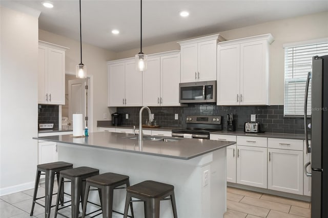 8942 Cabot Cliffs Dr, Davenport, FL 33896 - kitchen featuring stainless steel appliances, a breakfast bar, white cabinetry, and recessed lighting