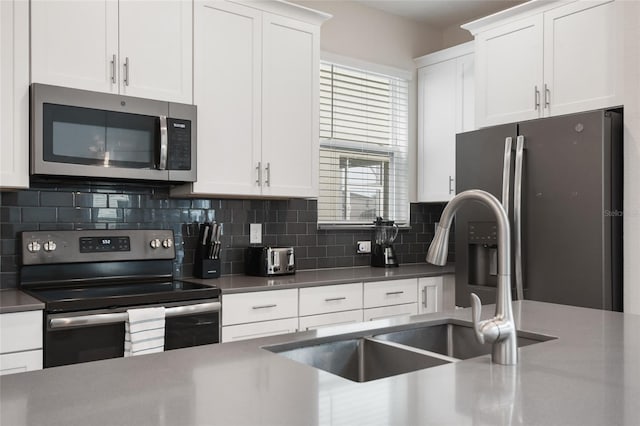 kitchen with white cabinetry, sink, appliances with stainless steel finishes, and tasteful backsplash