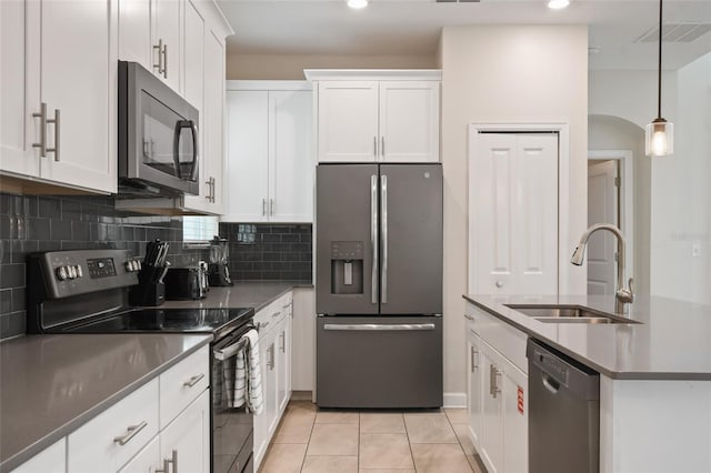 8942 Cabot Cliffs Dr, Davenport, FL 33896 - kitchen with stainless steel appliances, decorative backsplash, white cabinetry, pendant lighting, and light tile patterned flooring