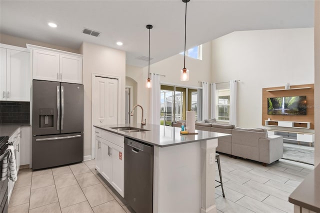 kitchen featuring hanging light fixtures, white cabinetry, sink, and stainless steel appliances