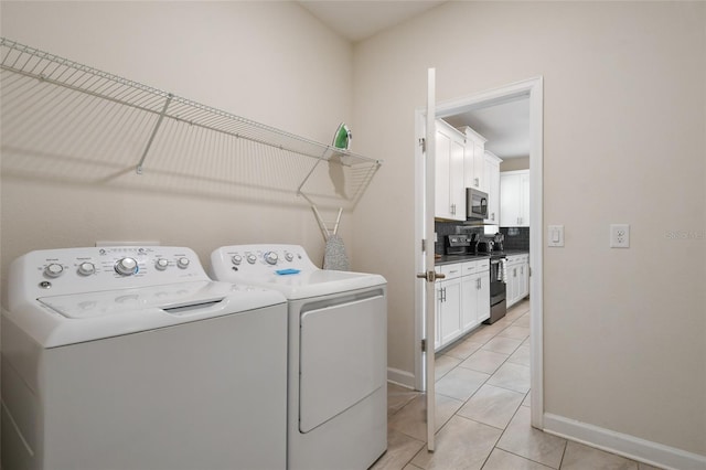 8942 Cabot Cliffs Dr, Davenport, FL 33896 - laundry area featuring washing machine and clothes dryer and light tile patterned floors