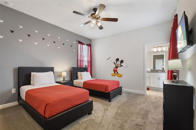 bedroom featuring light carpet, ensuite bath, and ceiling fan