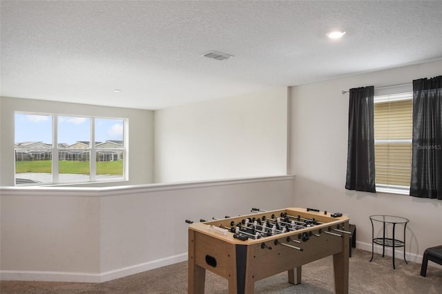 playroom featuring carpet flooring and a textured ceiling