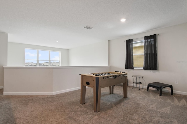 playroom featuring carpet flooring and a textured ceiling