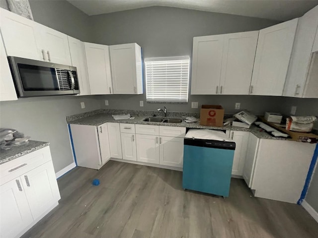 kitchen with appliances with stainless steel finishes, sink, light hardwood / wood-style flooring, white cabinetry, and lofted ceiling