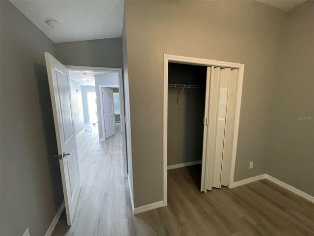 unfurnished bedroom with light wood-type flooring and a closet