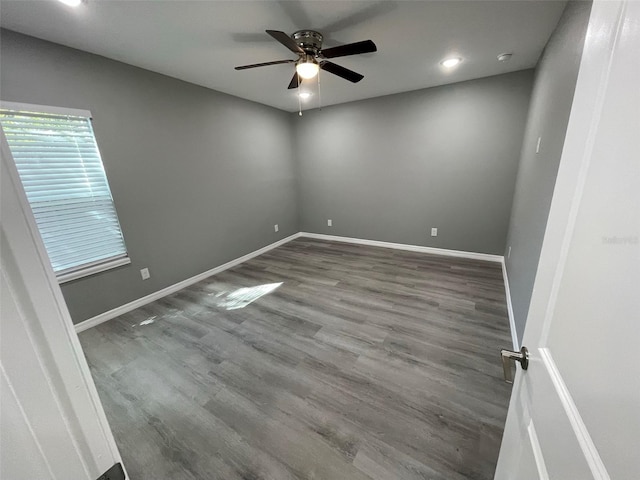 empty room with dark hardwood / wood-style flooring and ceiling fan