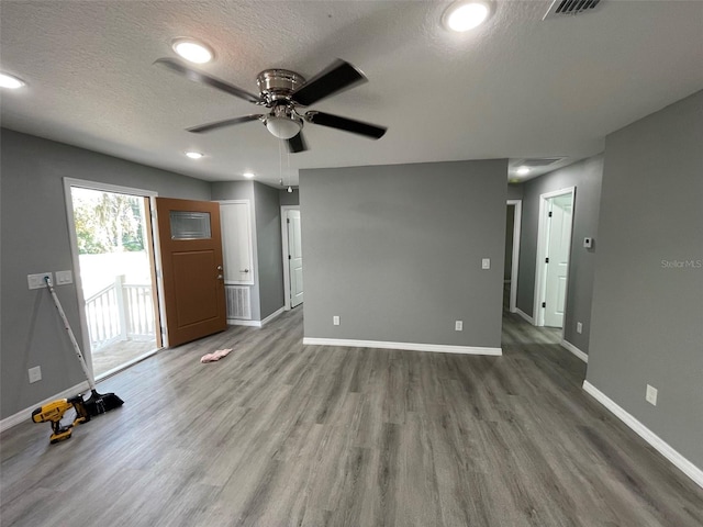 spare room featuring wood-type flooring, a textured ceiling, and ceiling fan