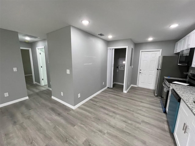 kitchen featuring white cabinets, light wood-type flooring, and appliances with stainless steel finishes