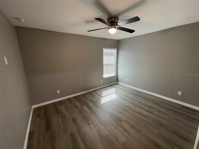 empty room featuring dark hardwood / wood-style flooring and ceiling fan