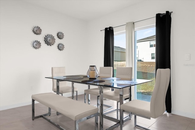 dining room featuring light tile patterned floors and baseboards