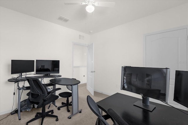 office space featuring light carpet, ceiling fan, visible vents, and baseboards