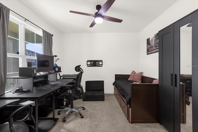 home office with a ceiling fan and light carpet