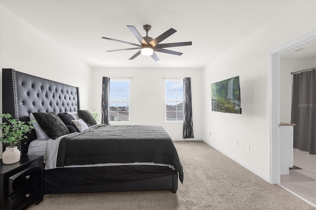 bedroom with a ceiling fan, light colored carpet, and baseboards