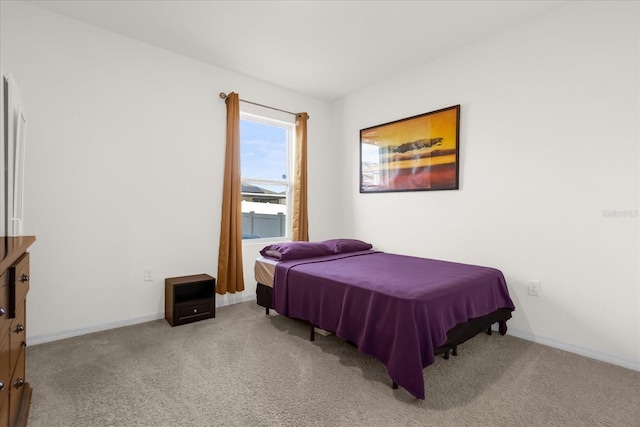 bedroom with light colored carpet and baseboards