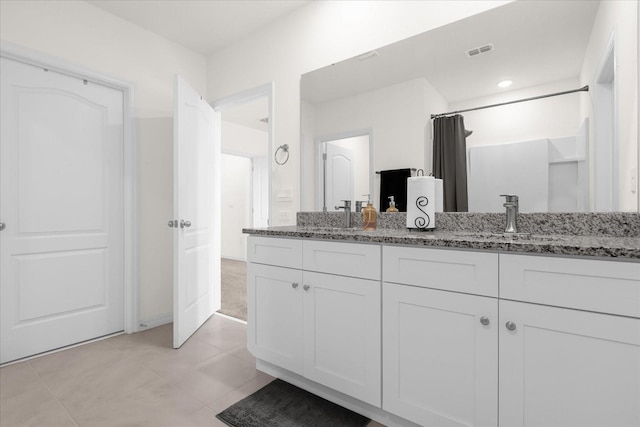 bathroom featuring double vanity, tile patterned flooring, a sink, and visible vents