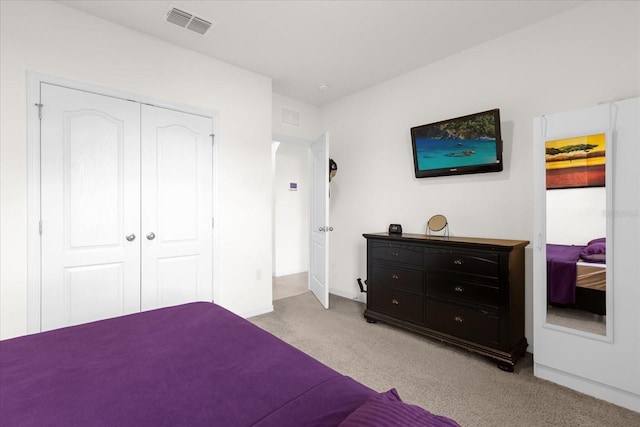 bedroom featuring a closet, visible vents, and light colored carpet