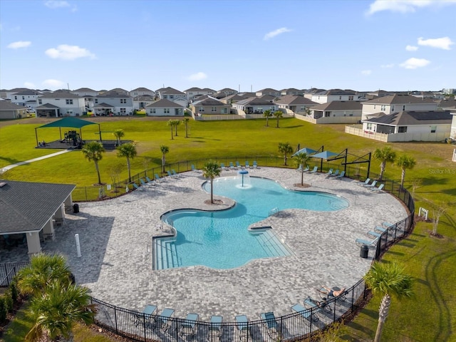 pool featuring a residential view, fence, and a lawn