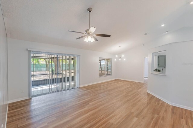 unfurnished room featuring vaulted ceiling, light hardwood / wood-style flooring, and a healthy amount of sunlight