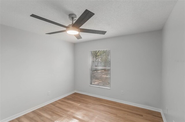 unfurnished room with a textured ceiling, light wood-type flooring, and ceiling fan