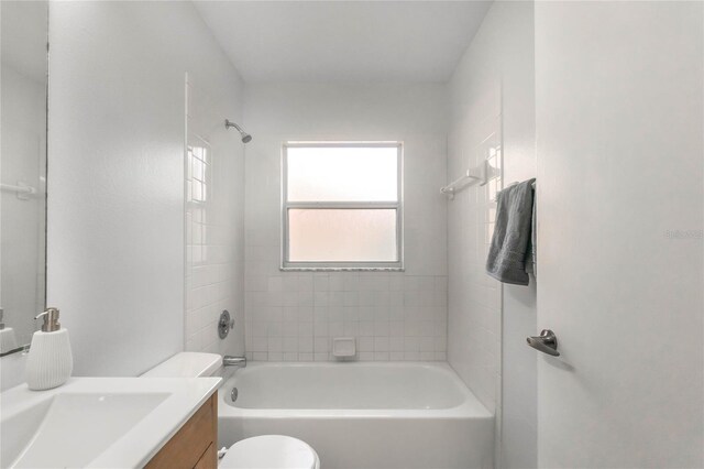 full bathroom with tiled shower / bath combo, toilet, and vanity