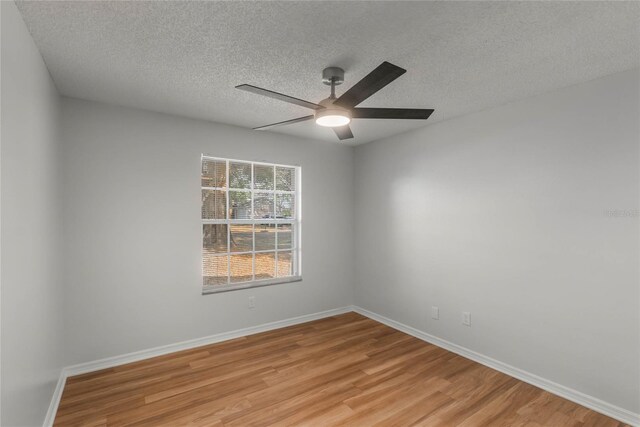 unfurnished room with a textured ceiling, light wood-type flooring, and ceiling fan