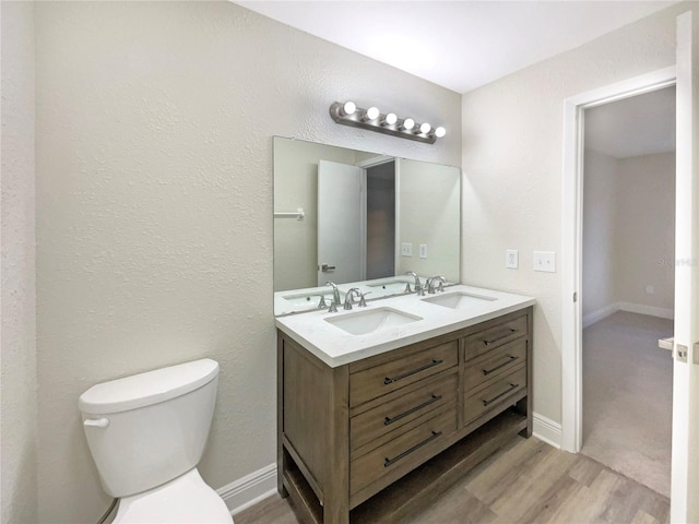 bathroom with hardwood / wood-style floors, vanity, and toilet