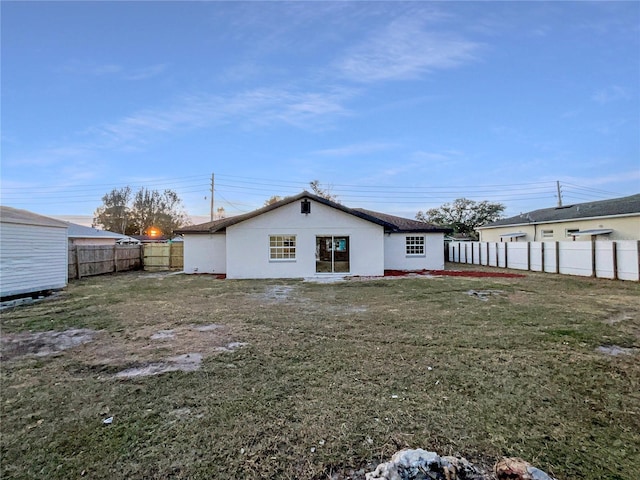 rear view of property featuring a lawn