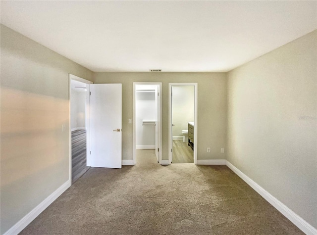 unfurnished bedroom featuring carpet and a walk in closet