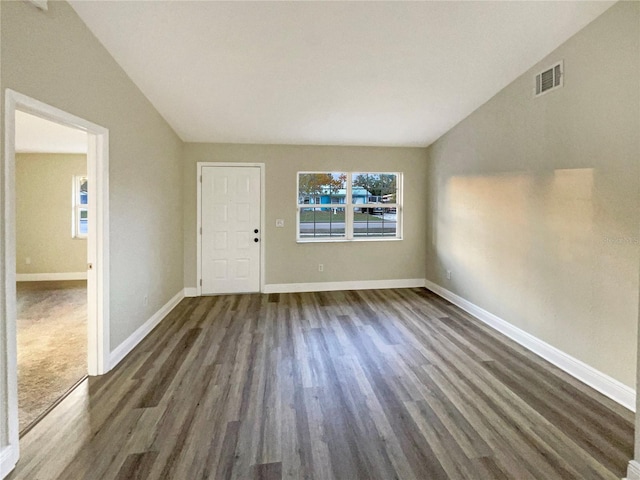 interior space featuring lofted ceiling and dark wood-type flooring