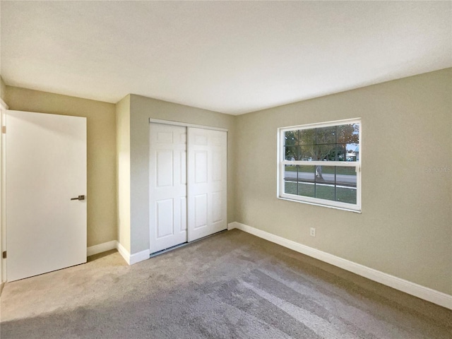 unfurnished bedroom with carpet flooring and a closet