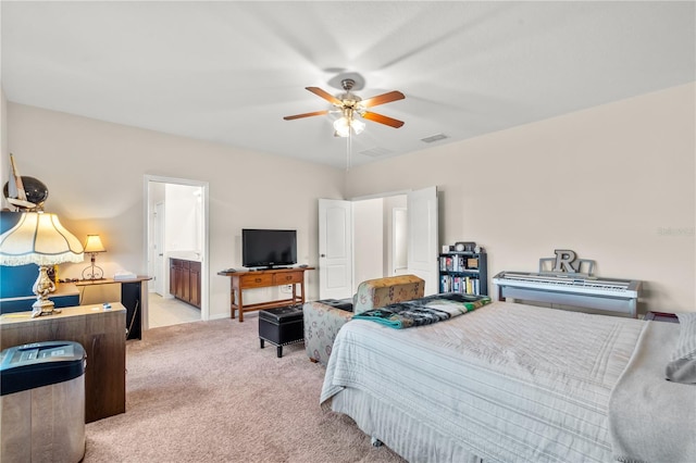 bedroom featuring light colored carpet, ensuite bath, and ceiling fan