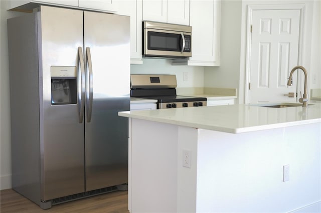 kitchen featuring white cabinetry, sink, stainless steel appliances, kitchen peninsula, and wood-type flooring