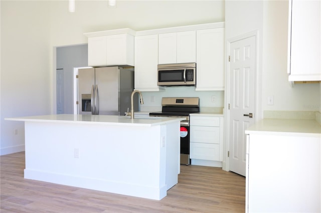 kitchen featuring a kitchen island with sink, white cabinetry, sink, and appliances with stainless steel finishes